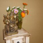 Ganesha-Figur mit Blumen auf kleinem Tisch