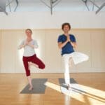 Zwei Yogapraktizierende im Baum (Vrksasana)